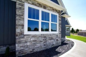 stylish windows with white frames set in a stone sided home